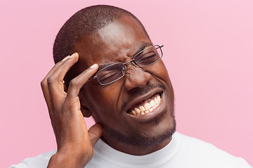 Image showing Black man holding his head in pain and depression