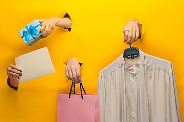 Image showing Female hand holding bright shopping bag and gifts