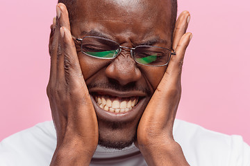 Image showing Black man holding his head in pain and depression