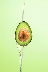 Image showing Fresh avocado and oil on green background