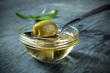 Image showing Olive oil and olive branch on the wooden table