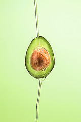 Image showing Fresh avocado and oil on green background