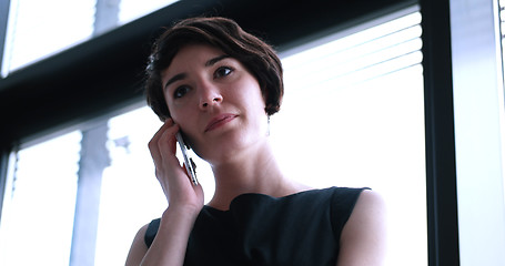 Image showing Business Girl Standing In A Modern Building Near The Window With