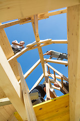 Image showing Builders at work with wooden roof construction.