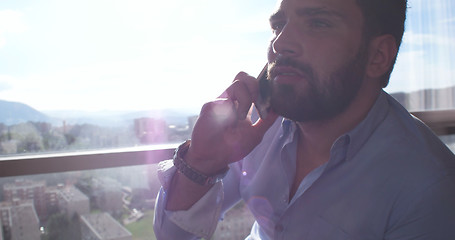 Image showing Business Man Talking On Cell Phone At Home