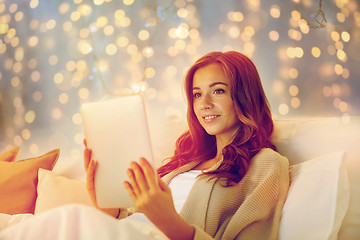 Image showing happy young woman with tablet pc in bed at home