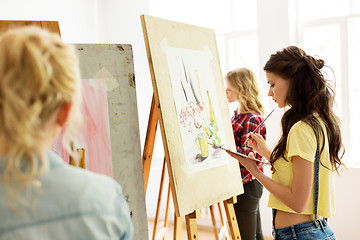 Image showing woman with easel painting at art school studio