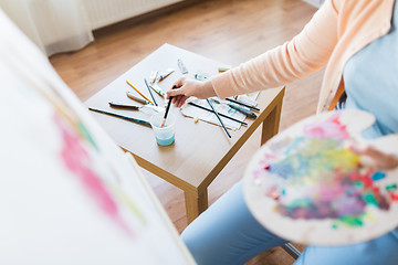 Image showing artist washing paintbrush at art studio