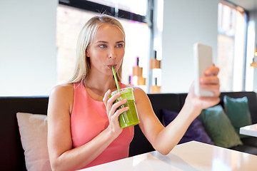 Image showing woman with smartphone taking selfie at restaurant