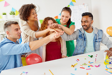 Image showing happy business team at office party holding hands