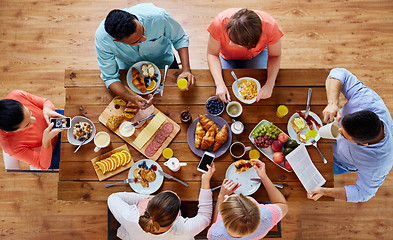 Image showing people with smartphones eating food at table