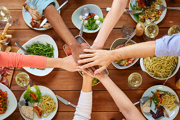 Image showing people holding hands together over table with food