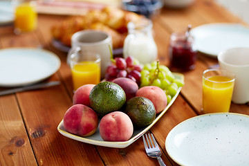 Image showing fruits, juice and other food on table at breakfast