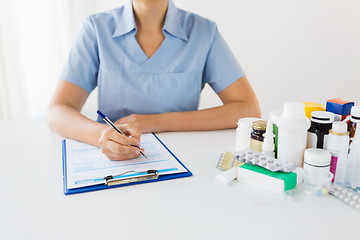 Image showing doctor with medicines and clipboard at hospital