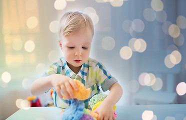 Image showing happy little baby boy with ball clay at home