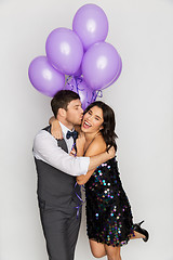Image showing happy couple with violet balloons kissing at party