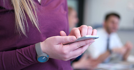 Image showing Close up of business woman using cell phone in office interior