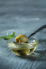 Image showing Olive oil and olive branch on the wooden table