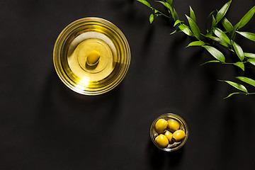 Image showing Olive oil and olive branch on the wooden table