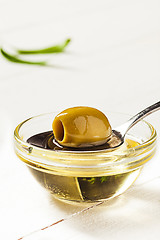 Image showing Olive oil and olive branch on the wooden table