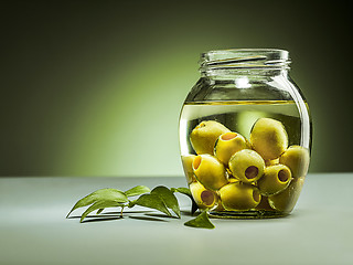 Image showing Olive oil and olive branch on the wooden table