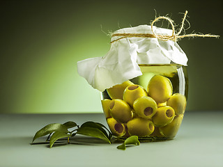 Image showing Olive oil and olive branch on the wooden table