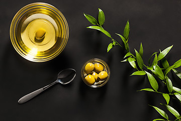 Image showing Olive oil and olive branch on the wooden table