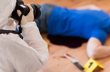 Image showing criminalist photographing dead body at crime scene