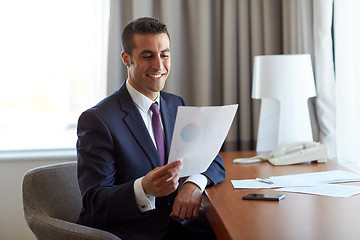 Image showing businessman with papers working at hotel room