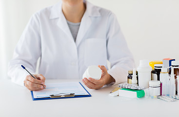 Image showing doctor with medicines and clipboard at hospital