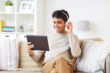 Image showing man in phones with tablet pc listening to music