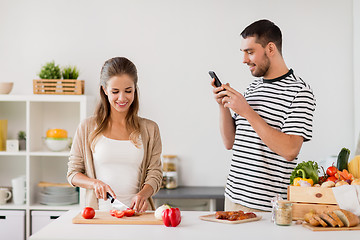 Image showing happy couple cooking food at home kitchen