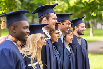 Image showing happy students or bachelors in mortar boards