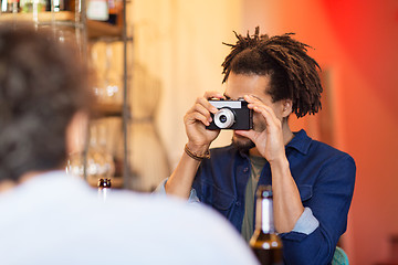 Image showing man with camera photographing friend at bar