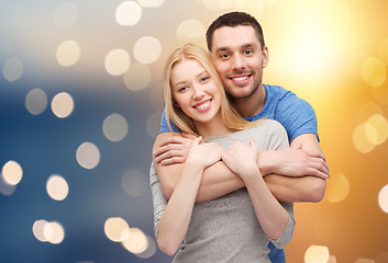 Image showing happy couple hugging over lights background