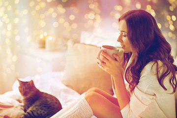 Image showing happy woman with cup of coffee in bed at home