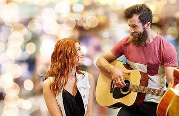 Image showing couple of musicians playing guitar over lights