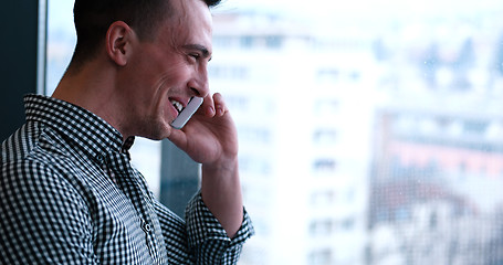 Image showing Business Man Talking On Cell Phone, Looking Out Office Window