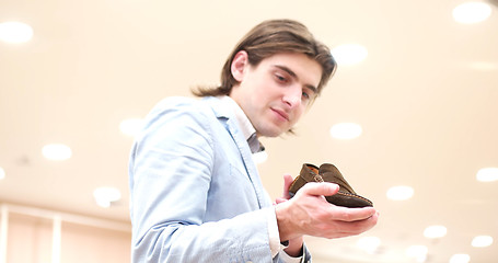 Image showing Man Chooses Shoes At Shoe Store