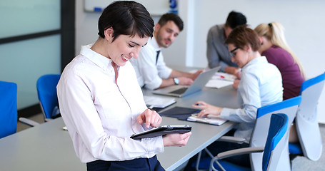 Image showing Businesswoman using tablet with coworkers in backgorund having m