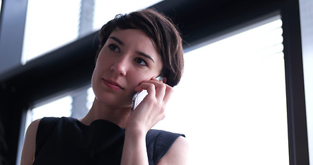 Image showing Business Girl Standing In A Modern Building Near The Window With