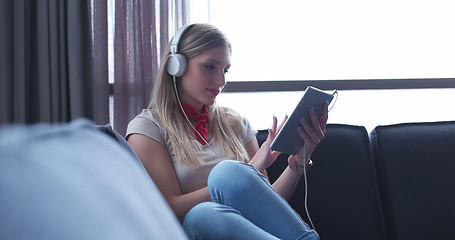 Image showing Lovely Blond Woman Listening To Music while resting on couch