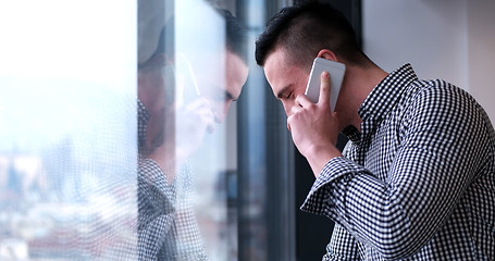 Image showing Business Man Talking On Cell Phone, Looking Out Office Window