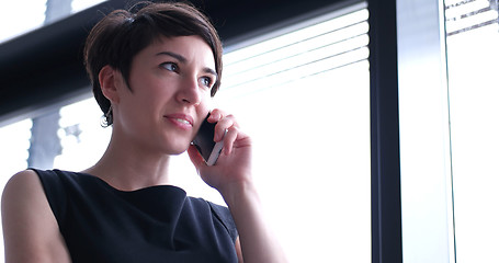 Image showing Business Girl Standing In A Modern Building Near The Window With