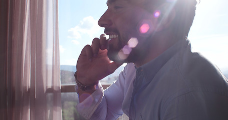 Image showing Business Man Talking On Cell Phone At Home