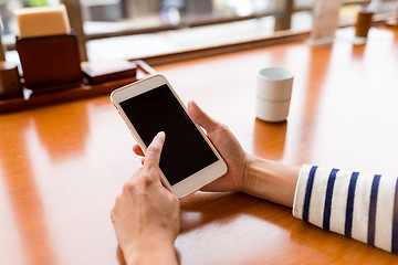 Image showing Woman using cellphone in restaurant