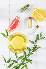 Image showing Lemon oil isolated on white wooden table