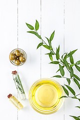 Image showing Olive oil and olive branch on the wooden table