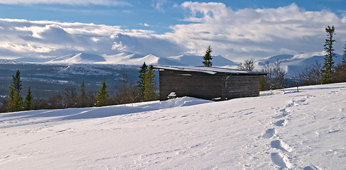 Image showing Winter panorama from Lifttoppen, footprints on snow, trees, clouds and a shelter, Vålådalen, Sweden