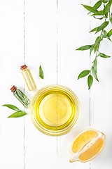 Image showing Lemon oil isolated on white wooden table